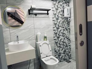 een badkamer met een toilet, een wastafel en een spiegel bij Arte Cheras 022 with 6 pax in Kuala Lumpur