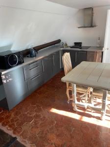- une cuisine avec une table, une table et des chaises dans l'établissement Au Bois Dormant, à Chilly-Mazarin
