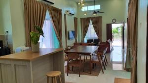 una sala da pranzo e un soggiorno con tavolo e sedie. di Duyong Damai Homestay by KOWBMAS a Malacca