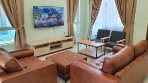 uma sala de estar com um sofá e duas cadeiras em Duyong Damai Homestay by KOWBMAS em Malaca