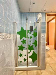 a bathroom with a shower with green stars on the wall at Apartamento E&D in Nerja