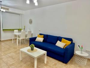 un soggiorno con divano blu e tavolo bianco di Apartamento E&D a Nerja