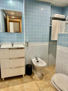 bagno piastrellato blu con servizi igienici e lavandino di Apartamento E&D a Nerja