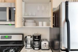 a kitchen with white cabinets and a refrigerator at FiDi studio w gym doorman nr Freedom Tower NYC-1088 in New York