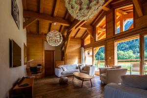 uma sala de estar com um grande tecto de madeira com janelas em Chalet Crêt Beni em La Chapelle-dʼAbondance