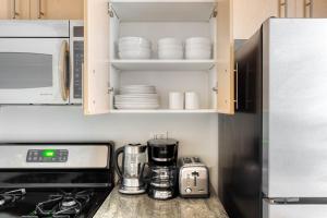 a kitchen with a stove and a refrigerator at FiDi studio w gym doorman nr Freedom Tower NYC-1089 in New York