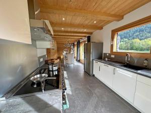 a kitchen with a stove and a sink and a window at Chalet Crêt Beni in La Chapelle-dʼAbondance