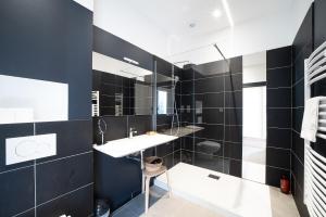 ein schwarzweißes Bad mit einem Waschbecken und einem Spiegel in der Unterkunft La Vie est Belle - Entre ski et thermes in Ax-les-Thermes