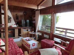 a living room with red furniture and a large window at Chalet Cèdre Rouge in Enchastrayes