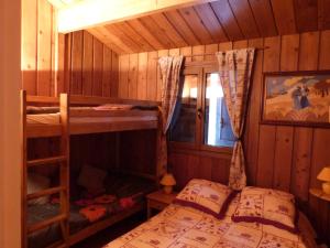 a bedroom with two bunk beds in a cabin at Chalet Cèdre Rouge in Enchastrayes