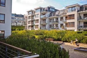 a row of apartment buildings with a garden at Luxury Bianco Apartament in Sopot