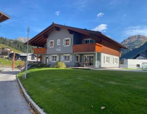 a house with a green lawn in front of it at Chalet Toda in Lech am Arlberg