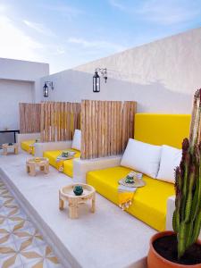 a living room with yellow couches and a cactus at Riad Citrus in Marrakech