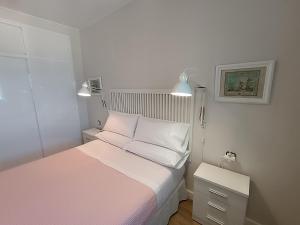 Habitación pequeña con cama y mesita de noche en Villablanca Apartamento, en Chipiona