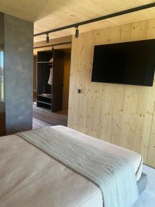 - une chambre dotée d'une télévision sur un mur en bois dans l'établissement Quinta das Areias - Solar da Pena, à Braga