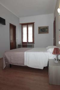 a bedroom with a large white bed and a desk at La Porta del Sole in Caselle Torinese