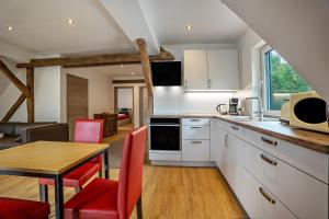 een keuken met een tafel en rode stoelen in een kamer bij Ferienwohnung Seeblick in Bad Bodenteich