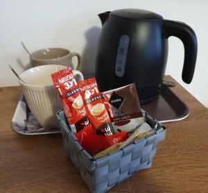 um cesto de comida numa mesa com um bule de chá em Citylife Rooms em Mosonmagyaróvár