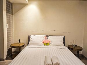 a bed with a stuffed animal sitting on top of it at Aksara de jiva at Pakuwon Indah Cluster in Surabaya