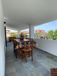 a dining room with a table and chairs on a balcony at Caletta Relax by Blu Sardinia in La Caletta