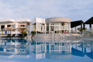 a building with a pool in front of it at Akti Dimis Hotel in Tigaki