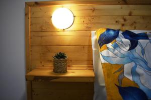 Una habitación con una cama con una lámpara y una planta sobre una mesa en Art Village Residence, en Bisceglie