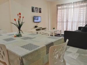 波德申的住宿－Sweet Homestay，客厅配有桌椅和电视。