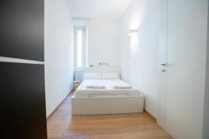 ein kleines weißes Schlafzimmer mit einem weißen Bett und einem Fenster in der Unterkunft Beautiful apartment in Sta Maria delle Grazie by Easylife in Mailand