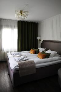 een slaapkamer met een groot bed met kussens bij Högbo Brukshotell & Spa in Sandviken