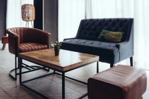 a living room with a couch and a chair and a coffee table at ONOMO Airport Casablanca in Casablanca