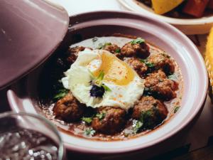 a bowl of food with meatballs and an egg on top at ONOMO Airport Casablanca in Casablanca
