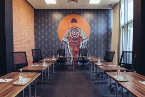 a room with tables and a large painting on the wall at ONOMO Airport Casablanca in Casablanca