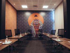 a room with tables and a large painting of a monkey at ONOMO Airport Casablanca in Casablanca