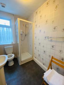 a bathroom with a shower and a toilet and a sink at Delamere Hotel in Blackpool +17 photos
