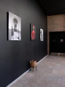 a room with three pictures on the wall and a chair at ONOMO Airport Casablanca in Casablanca
