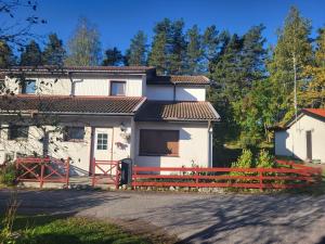 a house with a red fence in front of it at Nice home, where you can feel home at vikingavägen 75 in Gävle