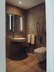 a bathroom with a sink and a toilet and a mirror at ONOMO Airport Casablanca in Casablanca