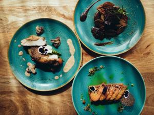 three blue plates of food on a wooden table at ONOMO Airport Casablanca in Casablanca