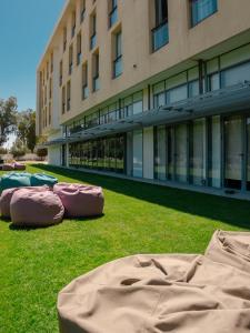 three mattresses laying on the grass in front of a building at ONOMO Airport Casablanca in Casablanca