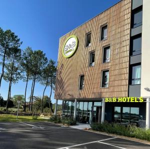 Un edificio con un gran reloj en el costado. en B&B HOTEL Saint-Geours-de-Maremne Hossegor, en Saint-Geours-de-Maremne