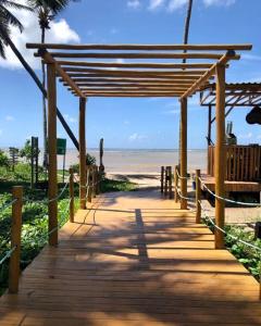 a wooden boardwalk leading to the beach with a view at Mani Milagres Studio - Gamboa Patacho in Pôrto de Pedras