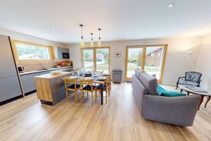 a kitchen and living room with a table and a couch at LA VILLA NATURA in Granges-Narboz