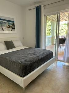 um quarto com uma cama grande e uma varanda em Casa Linda La Nucía Park em La Nucía