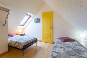 1 dormitorio con 2 camas y puerta amarilla en Chez Fanch, en Camaret-sur-Mer