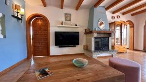 uma sala de estar com televisão e lareira em Finca Can Bagur Ventolra em Biniali