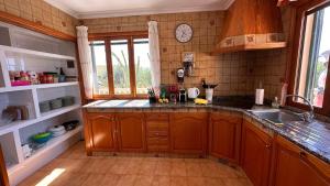 uma cozinha com armários de madeira e um lavatório em Finca Can Bagur Ventolra em Biniali