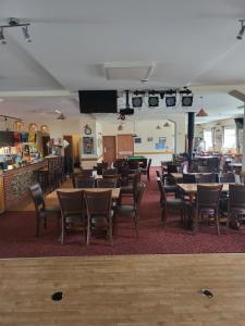 a restaurant with tables and chairs and a bar at The Cliff Top Inn in Bacton