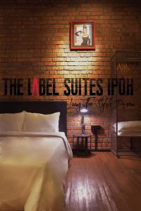 a bedroom with a bed and a brick wall at The Label Suites Ipoh in Ipoh