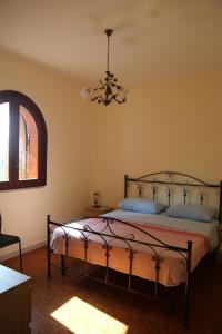 sypialnia z łóżkiem i żyrandolem w obiekcie Sole Nascente Apartment w mieście Giardini Naxos