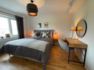 1 dormitorio con cama, escritorio y espejo en Feels Like Home en Gotemburgo